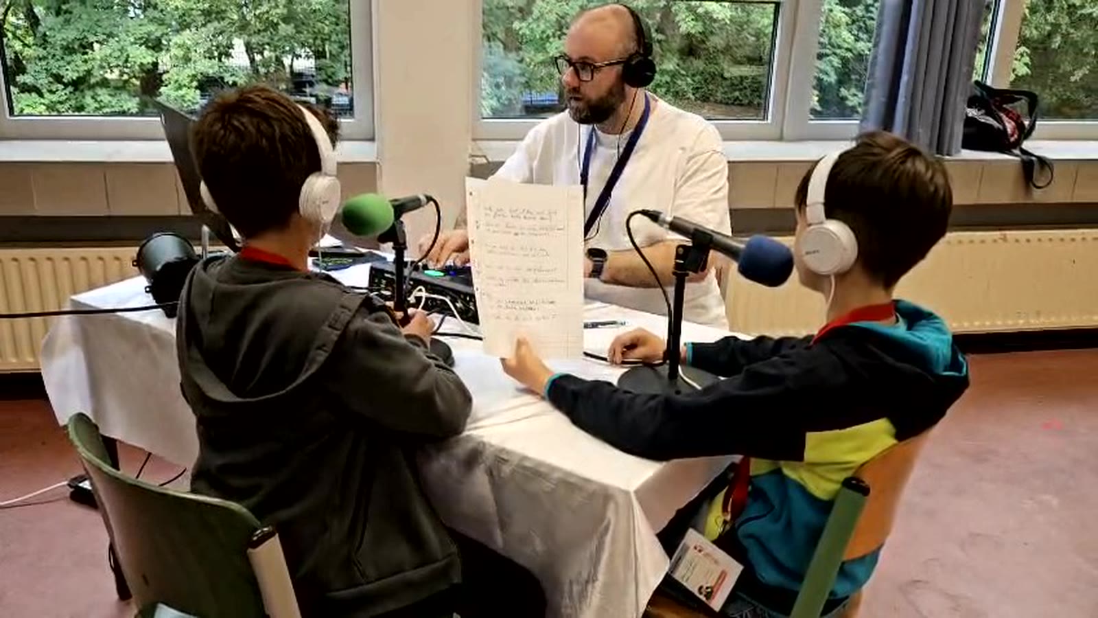 Radiotisch mit Manuskript, Mikrofonen und Kopfhörern