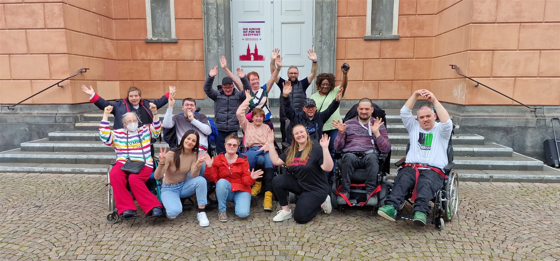 Die Redaktion von Inklusives Radio "On Air" grüßt gemeinsam vor einem Gebäude
